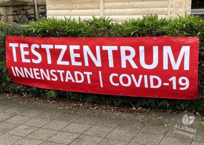 PVC-Banner für das Testzentrum Innenstadt in der Sophienstraße in Karlsruhe | montiert an einer Hecke